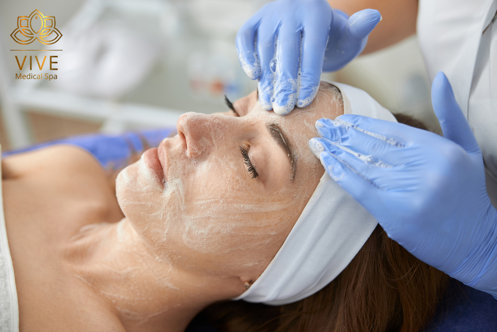 Woman receiving a rejuvenating facial cleansing treatment at Vive Medical Spa.
